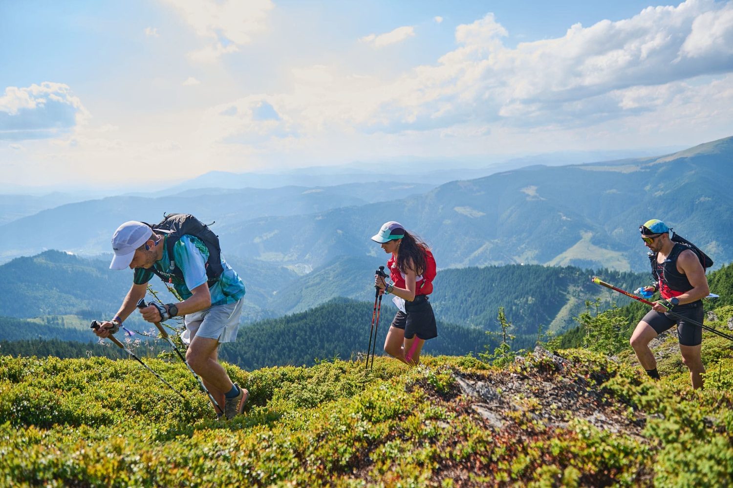 Corredores de trail en un sendero de cumbre con vista a la cordillera