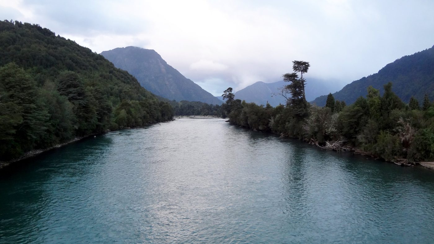 Palena River between forested hills, with low clouds